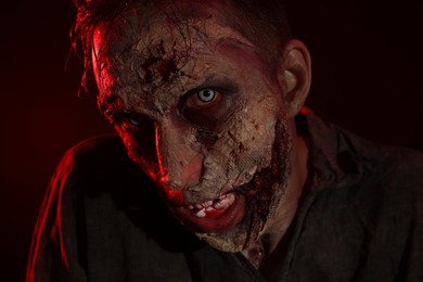 Scary zombie on dark background, closeup. Halloween monster