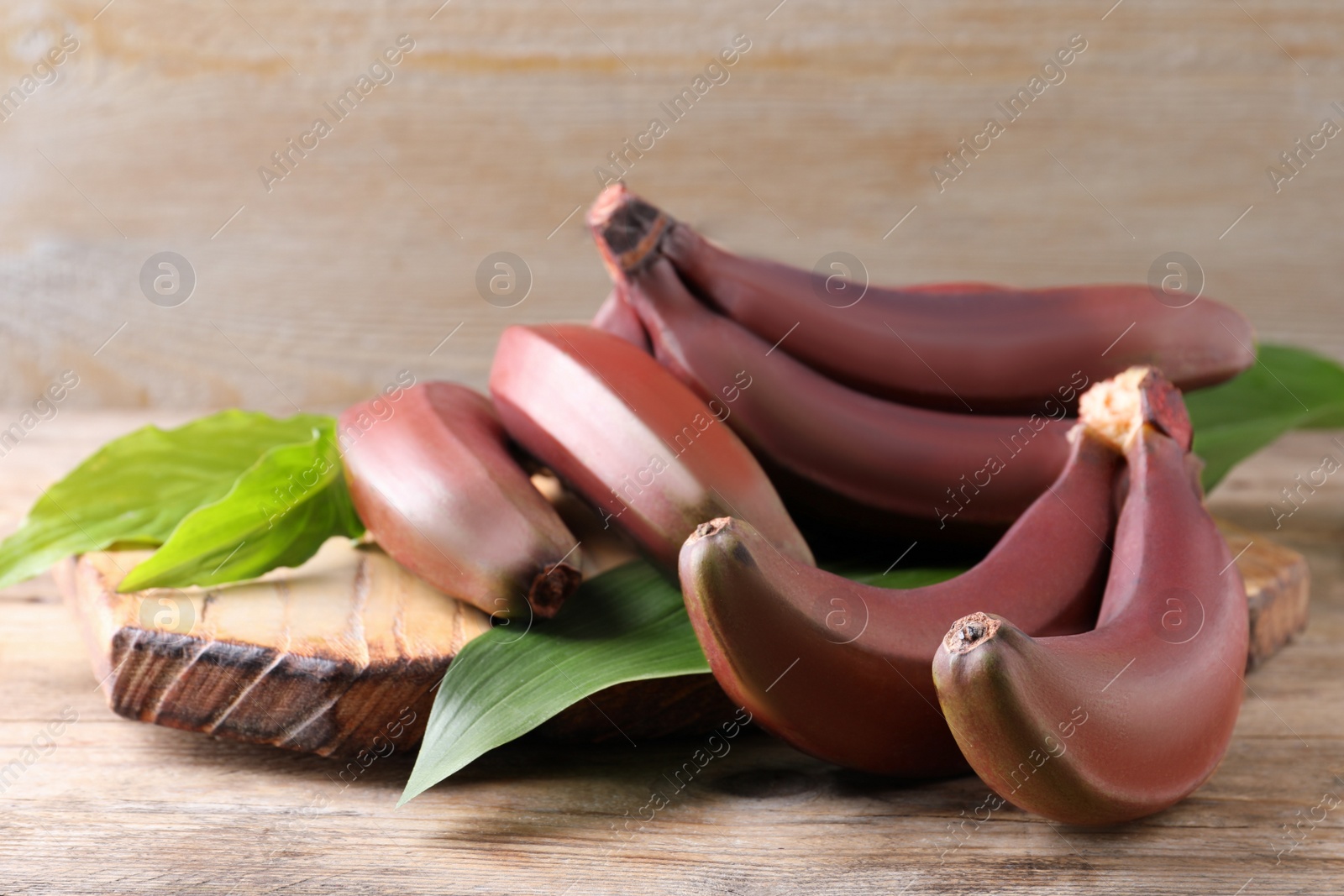 Photo of Delicious red baby bananas on wooden table