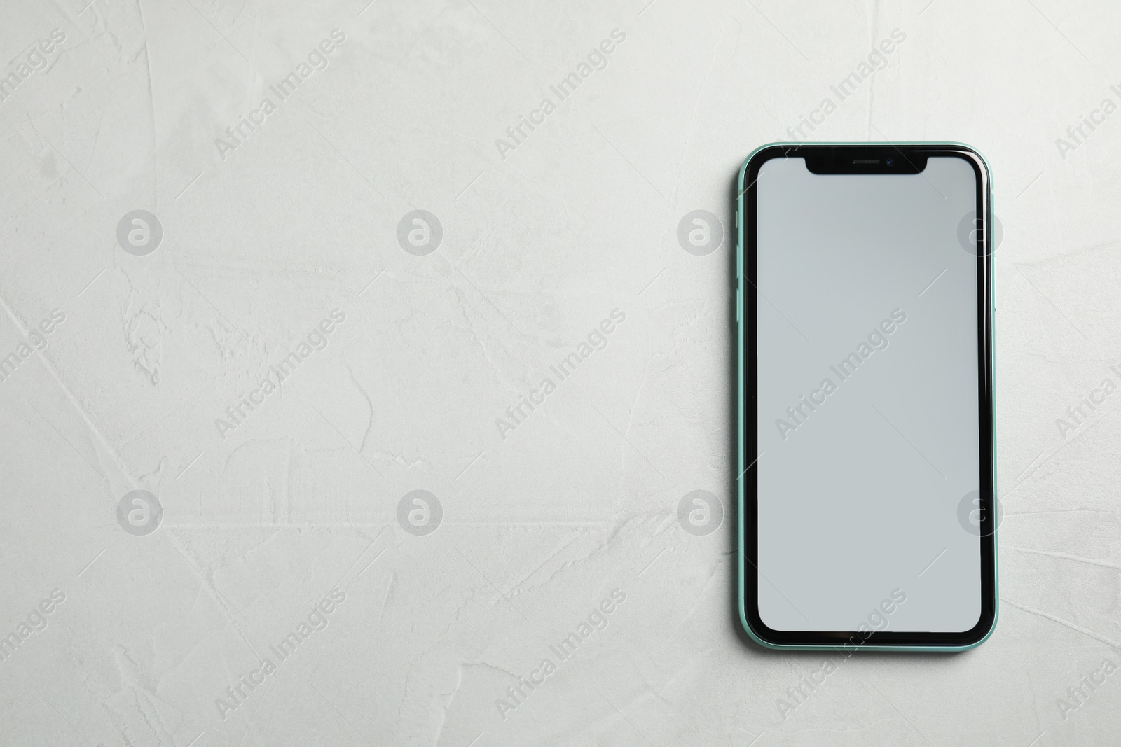 Photo of MYKOLAIV, UKRAINE - JULY 9, 2020: New modern Iphone 11 with blank screen on grey table, top view. Space for text