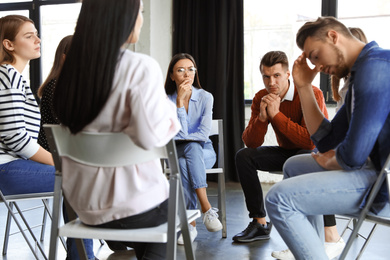 Photo of Psychotherapist working with patients in group therapy session indoors