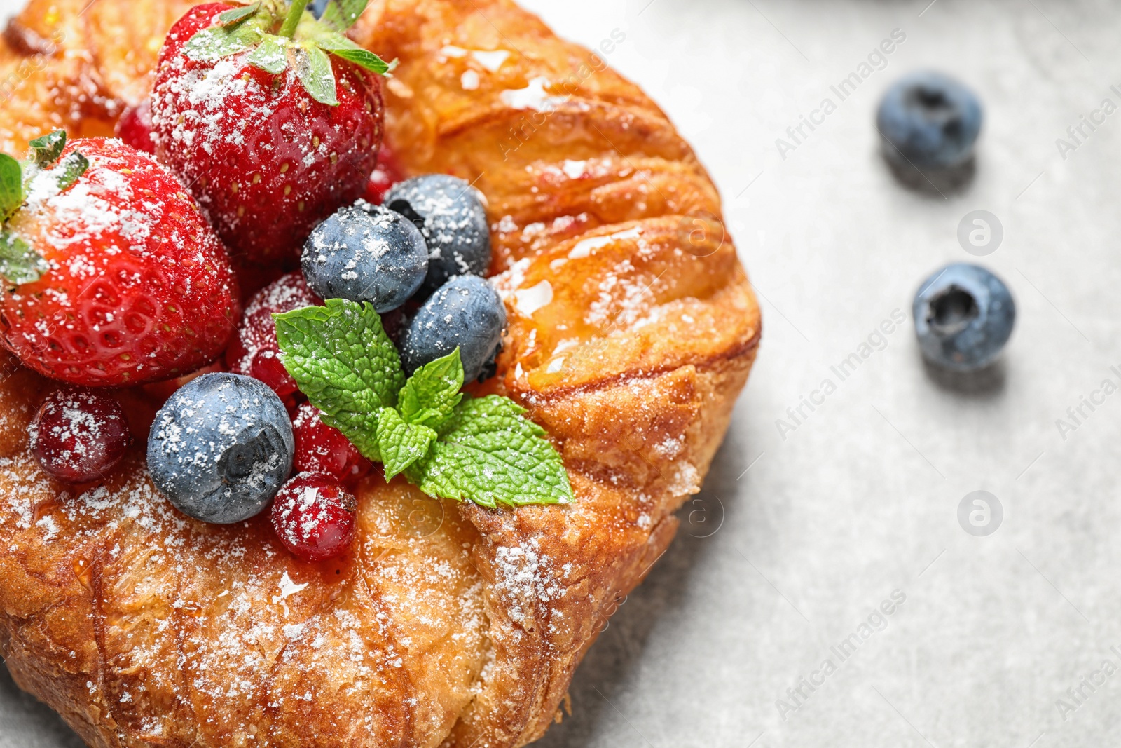 Photo of Fresh delicious puff pastry with sweet berries on light background, closeup