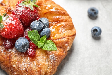 Fresh delicious puff pastry with sweet berries on light background, closeup