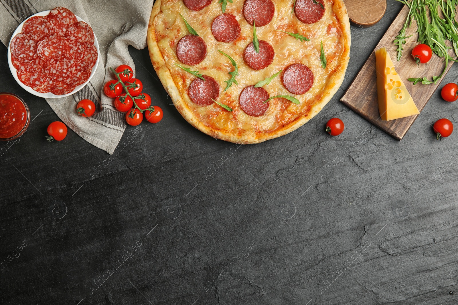 Photo of Flat lay composition with tasty pepperoni pizza on black table. Space for text
