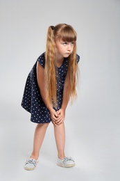 Photo of Full length portrait of little girl having knee problems on grey background