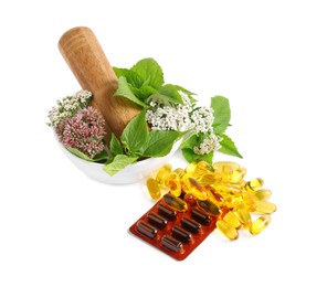 Photo of Mortar with fresh herbs and pills on white background