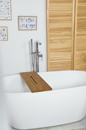 Photo of Stylish white tub in bathroom. Interior design