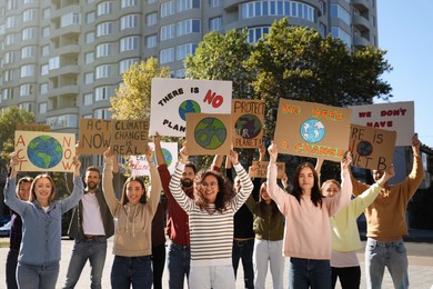 Photo of Group of people with posters protesting against climate change on city street