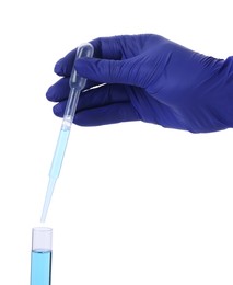 Scientist dripping liquid from pipette into test tube on white background, closeup