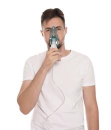 Man using nebulizer for inhalation on white background