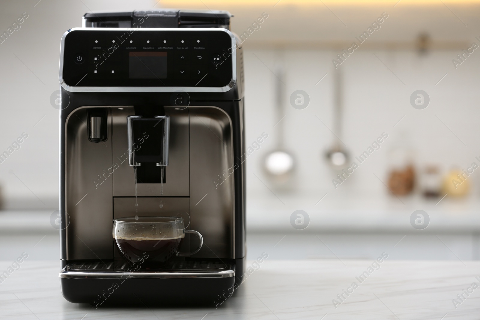 Photo of Modern electric espresso machine making coffee on white marble countertop in kitchen