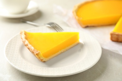 Photo of Slice of delicious homemade lemon pie on light grey table