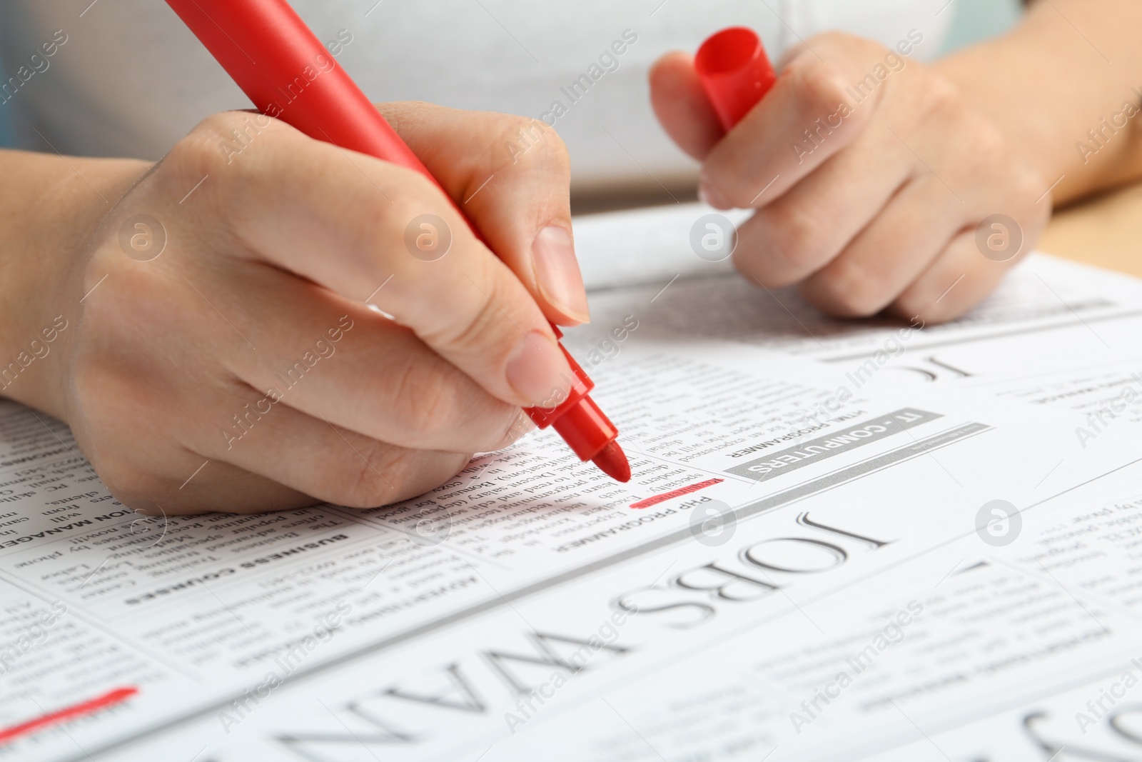 Photo of Woman marking advertisement in newspaper, closeup. Job search concept