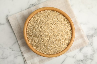 Photo of Bowl with white quinoa on marble table, top view