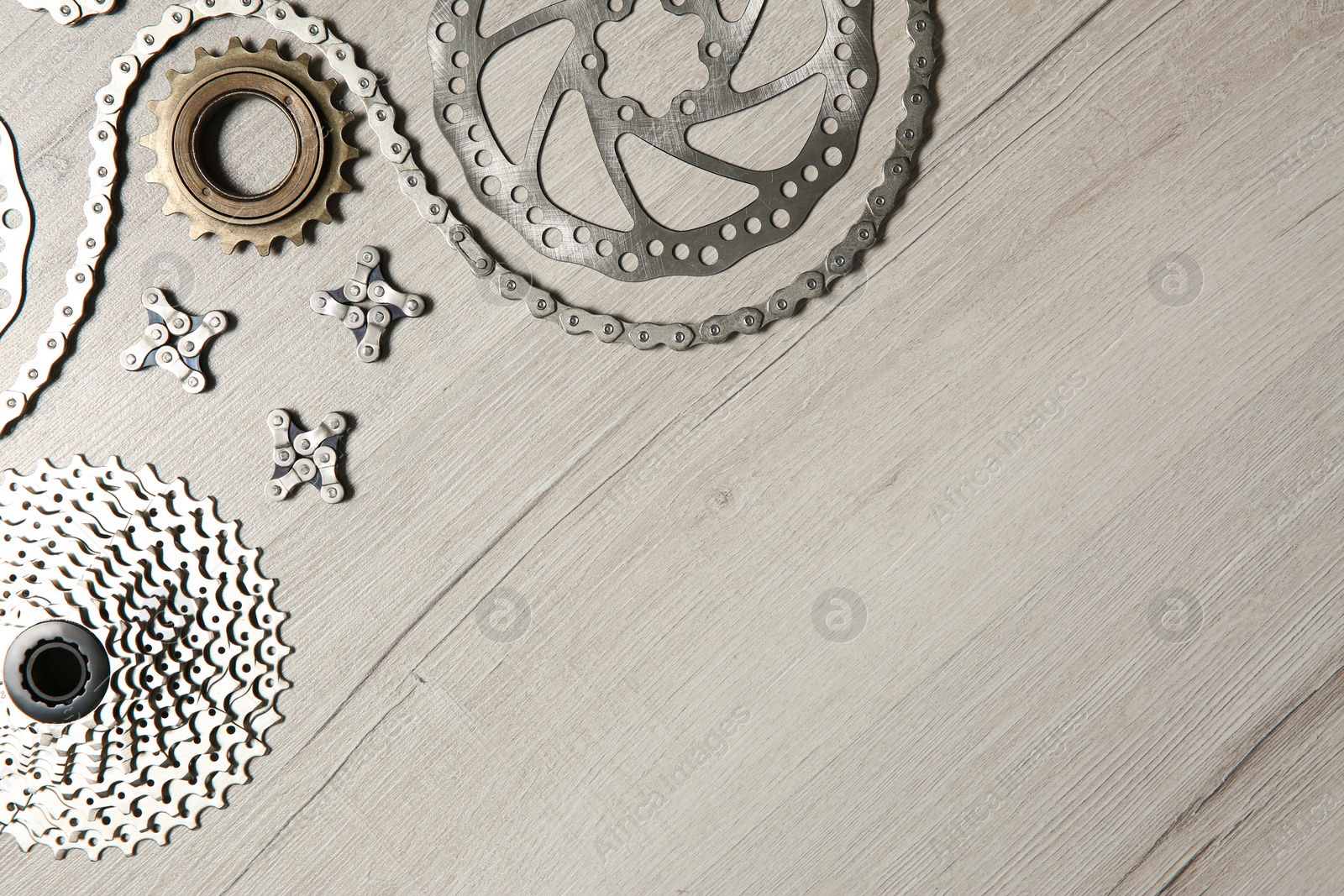 Photo of Set of different bicycle parts on wooden background, flat lay. Space for text