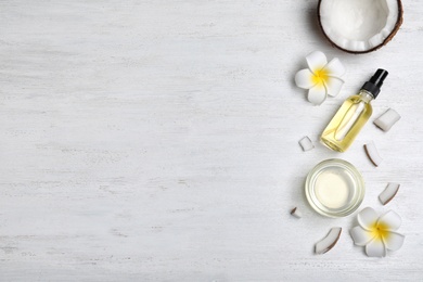 Flat lay composition with natural organic coconut oil on wooden background. Space for text