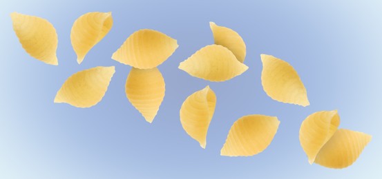 Raw conchiglie pasta flying on blue background