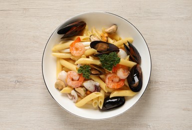 Photo of Delicious pasta with sea food on white wooden table, top view