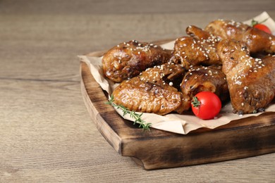 Photo of Tasty chicken glazed in soy sauce served on wooden table, closeup. Space for text