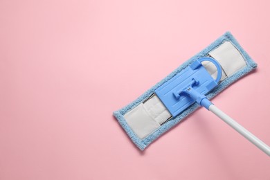 Photo of Mop with plastic handle on pink background, top view. Space for text