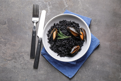 Photo of Delicious black risotto with seafood on grey table, flat lay