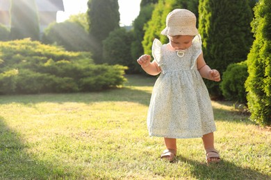 Photo of Cute little girl wearing stylish clothes outdoors on sunny day. Space for text