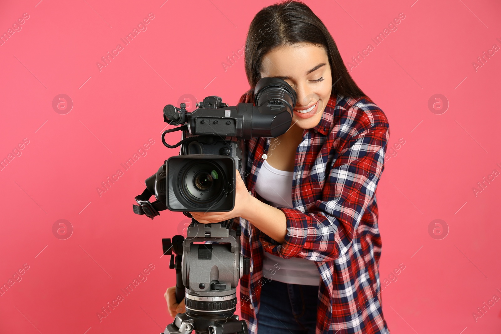 Photo of Operator with professional video camera on pink background