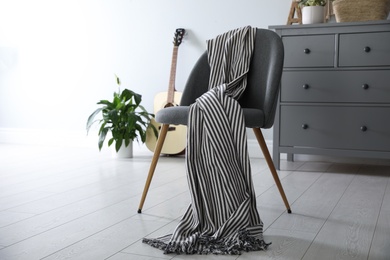 Photo of Chair with soft plaid in stylish room interior