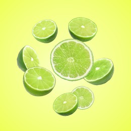 Image of Fresh lime fruits falling on green yellow background