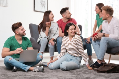 Group of happy people with laptop in living room
