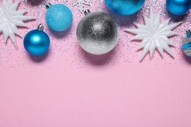 Photo of Shiny Christmas balls, decorative snowflakes and glitter on pink background, flat lay. Space for text