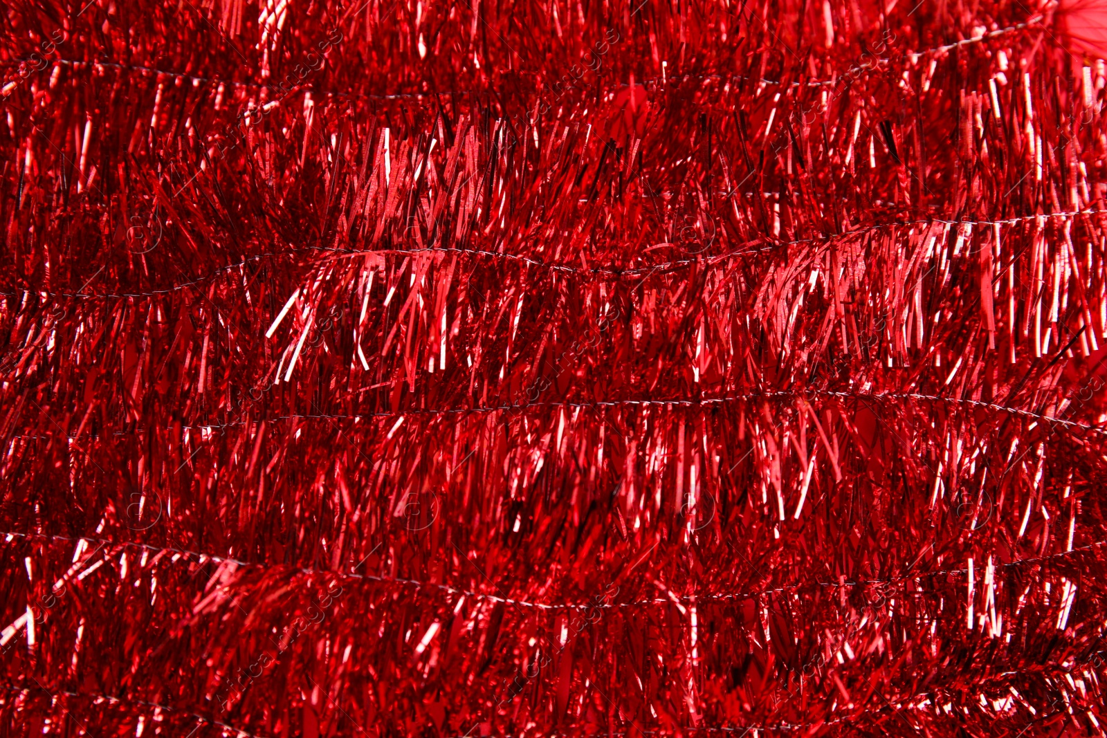 Photo of Bright red tinsel as background. Festive decoration