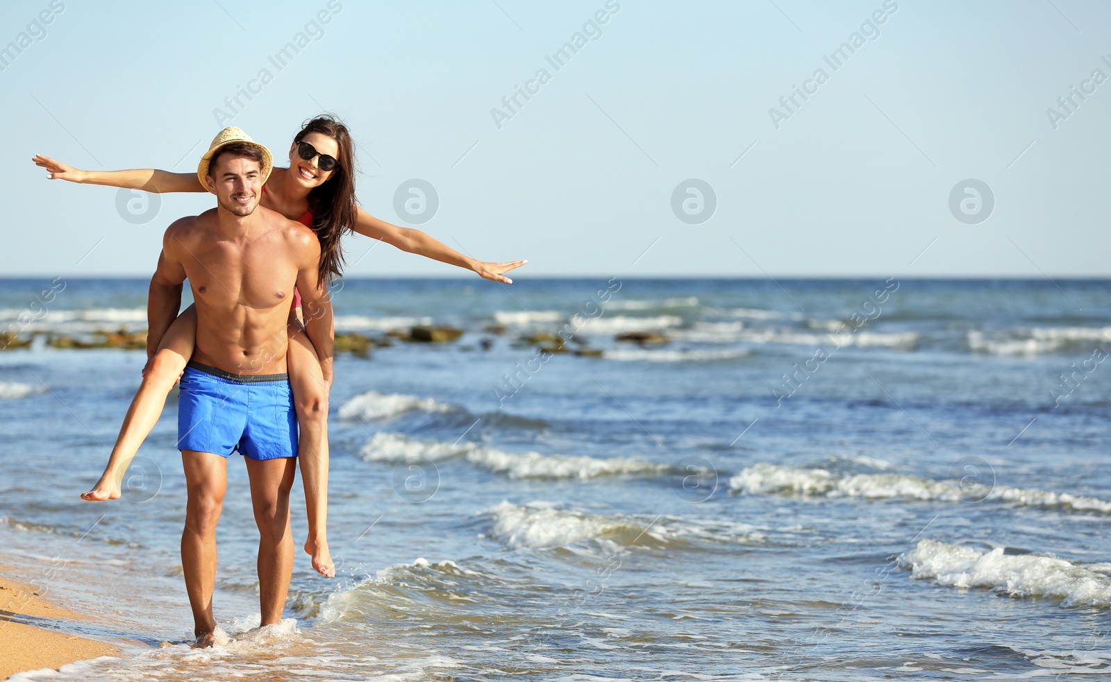 Photo of Happy young couple having fun at beach on sunny day