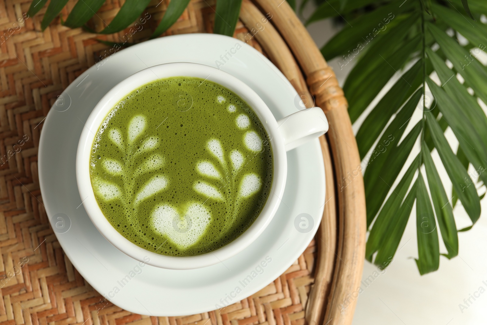 Photo of Delicious matcha latte in cup on coffee table, top view