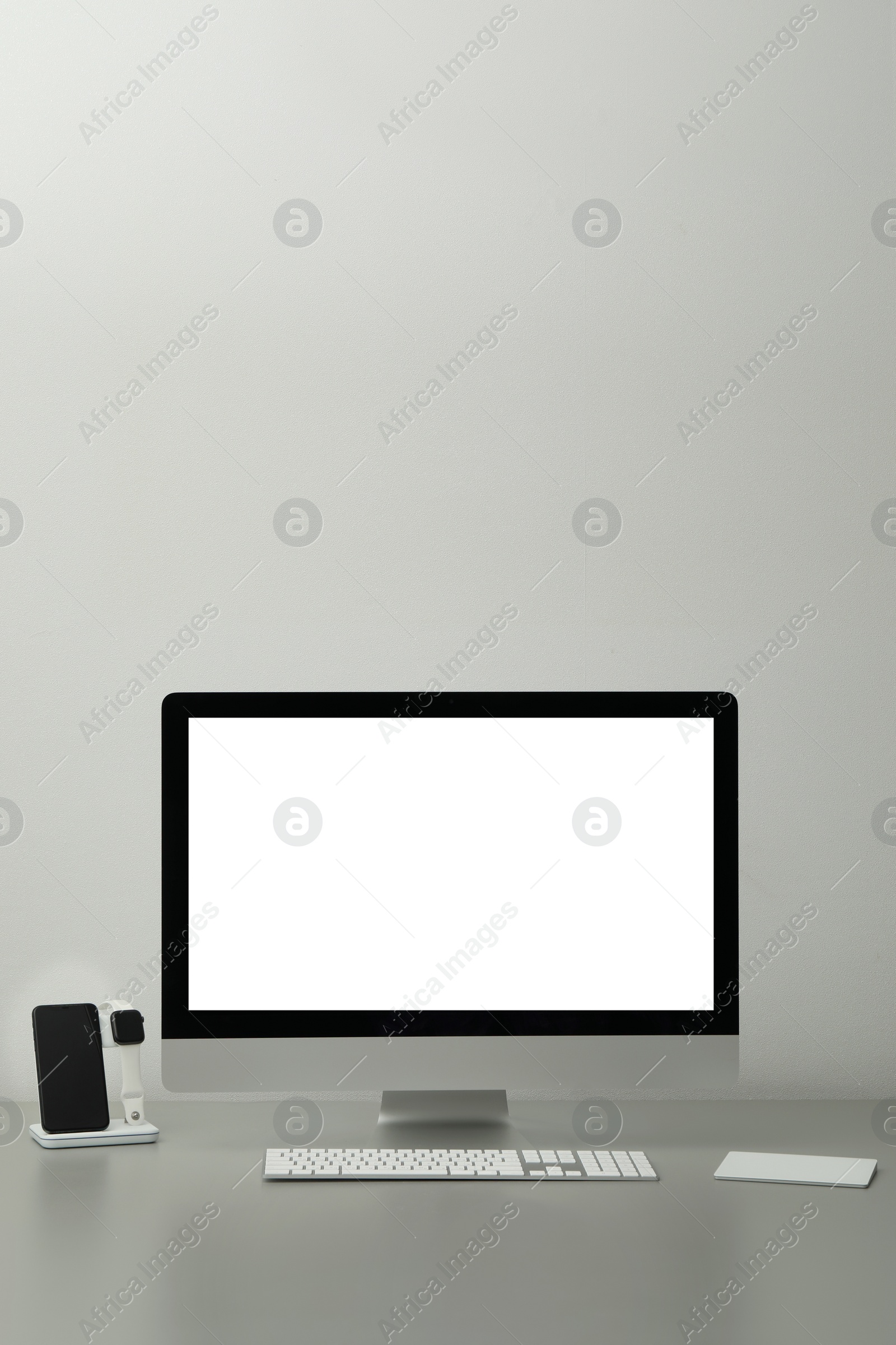 Photo of Modern workplace with computer and charging devices. Interior design