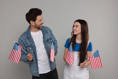 4th of July - Independence Day of USA. Happy father and his daughter with American flags on light grey background