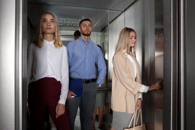 Group of office workers in modern elevator