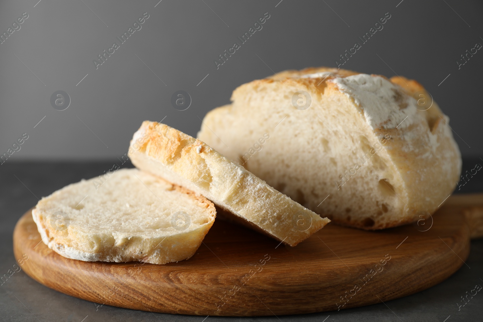 Photo of Freshly baked cut sourdough bread on grey table, closeup