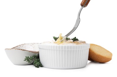Photo of Eating tasty baked camembert with fork from bowl on white background, closeup