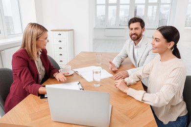 Photo of Real estate agent working with couple in new apartment