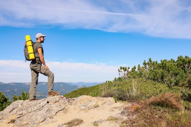 Photo of Man with backpack in mountains. Space for text