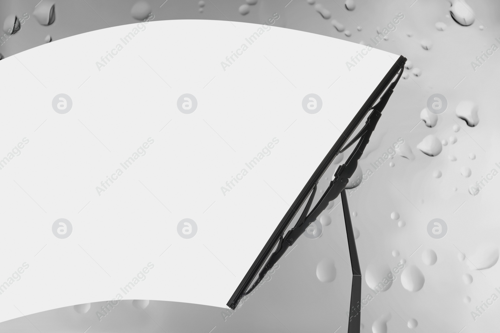 Image of Car windshield wiper cleaning water drops from glass