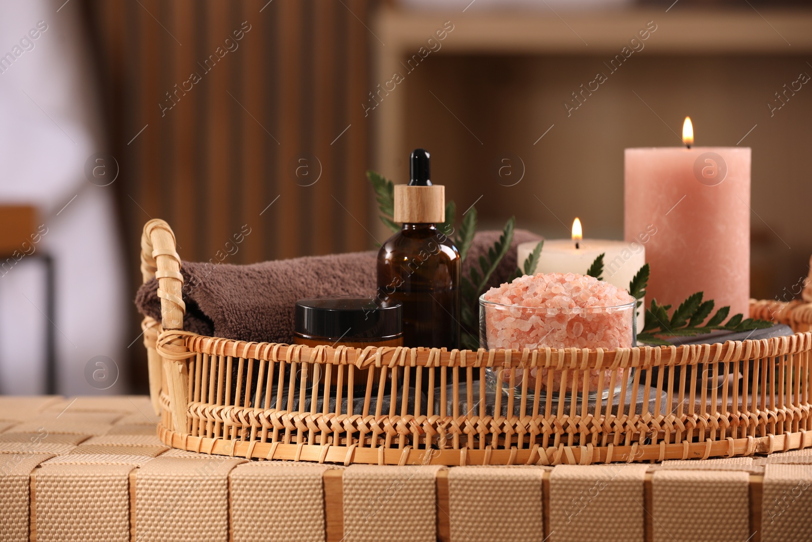 Photo of Beautiful composition with different spa products on wicker bench indoors