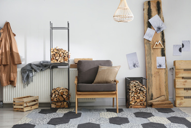 Photo of Stylish room interior with firewood as decorative element