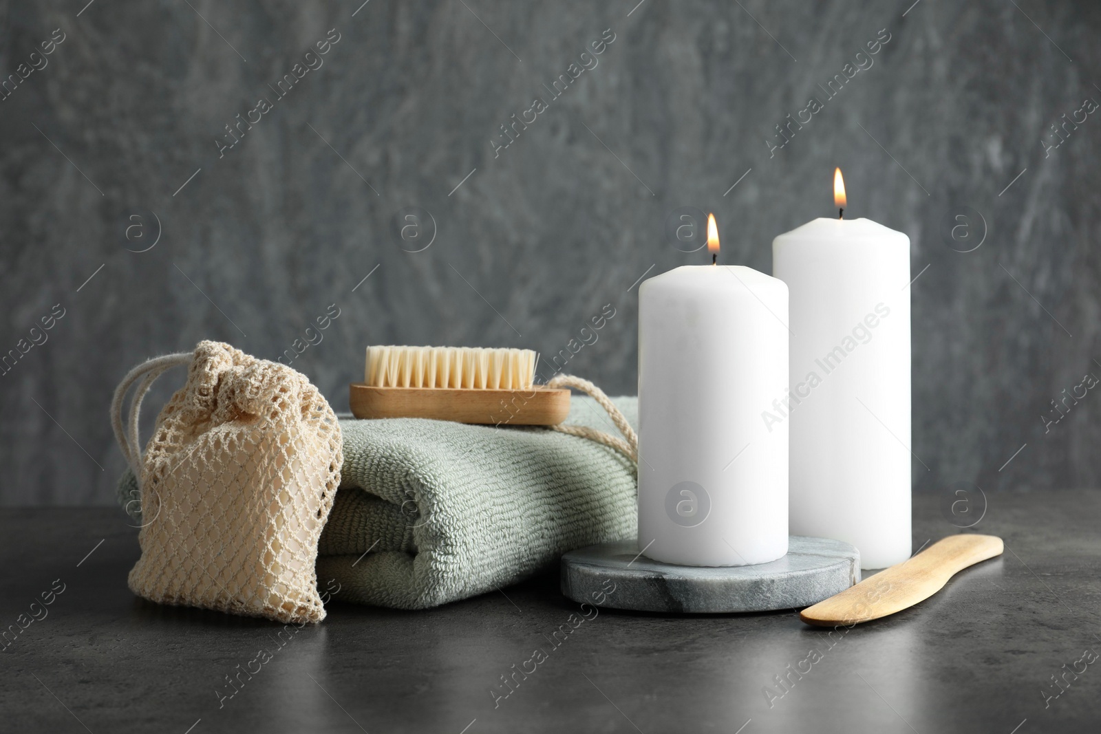 Photo of Composition with different spa products and burning candles on grey table