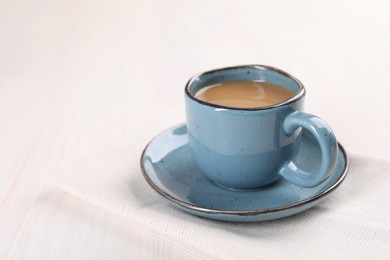 Delicious coffee in cup on white wooden table, closeup. Space for text