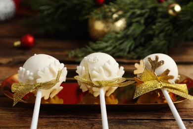 Delicious Christmas themed cake pops on wooden table, closeup