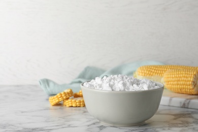 Photo of Bowl with corn starch on marble table. Space for text