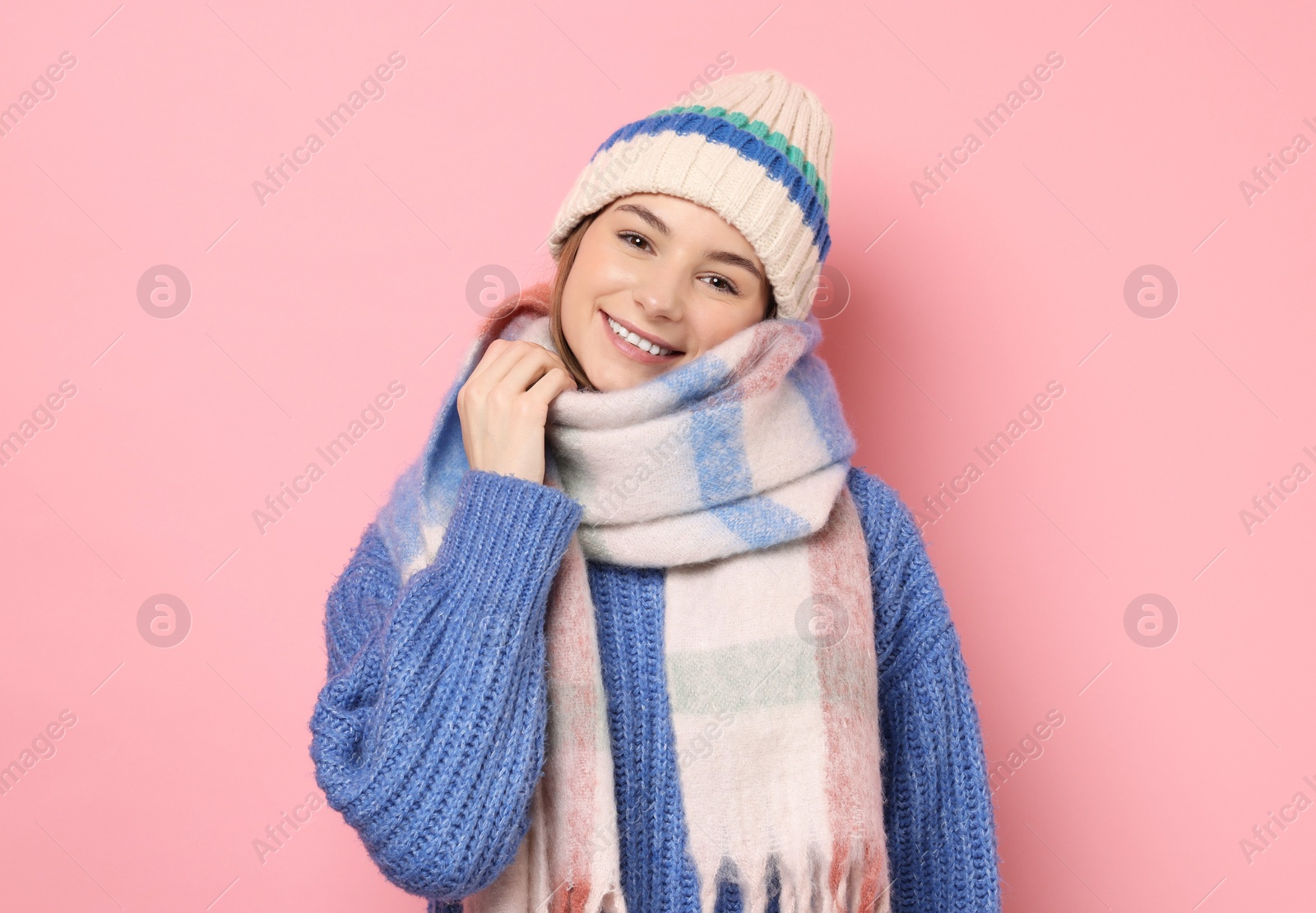 Photo of Beautiful woman in warm scarf and hat on pink background