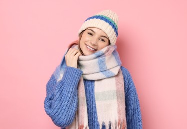 Photo of Beautiful woman in warm scarf and hat on pink background