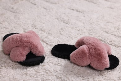 Photo of Colorful soft slippers on light carpet, closeup